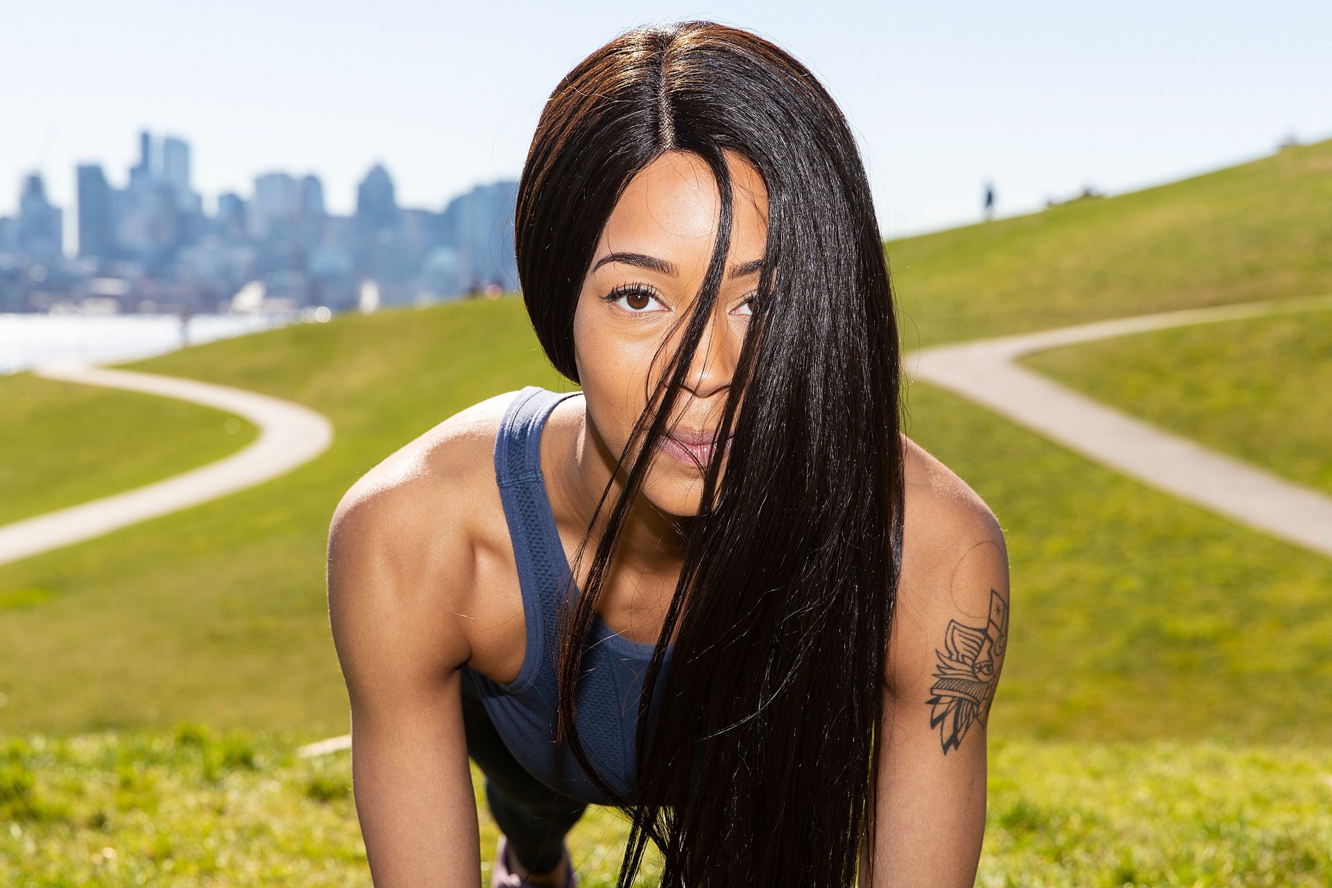 Healthy young African American woman with long black hair practicing yoga outside at Gasworks Park in Seattle, Washington